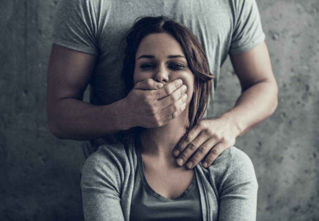 Femme se faisant fermer la bouge par la main d'un homme